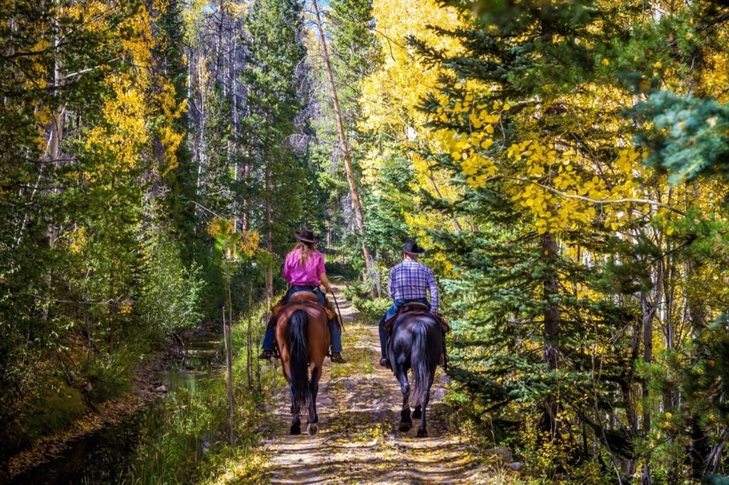 Photo of two people on horseback enjoying a romantic Colorado getaway