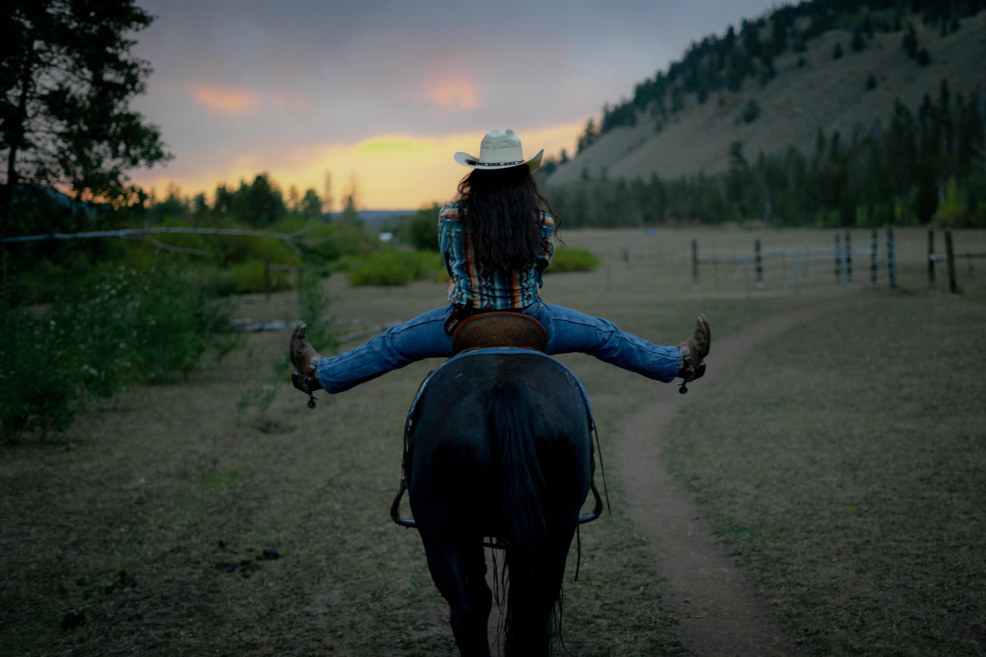 Photo of a person riding a horse at dusk at Rawah Ranch: a member of the dude ranchers association