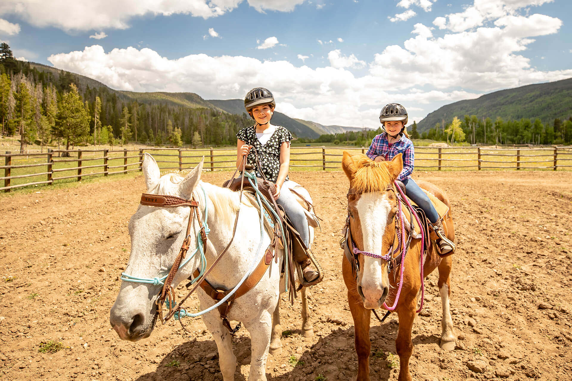 Kids riding horses during a Colorado family vacation at Rawah Ranch