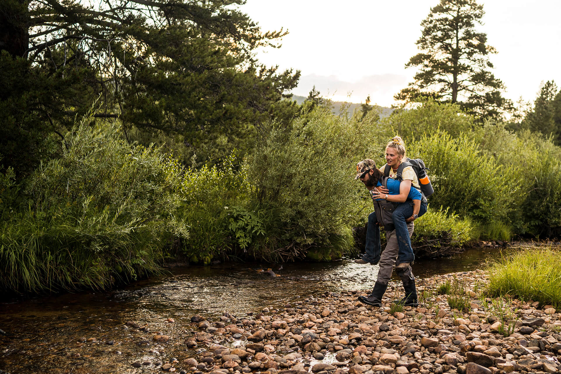 Person giving another a piggy back ride in nature during a romantic Colorado vacation